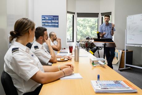 Student pilots and instructor in classroom.