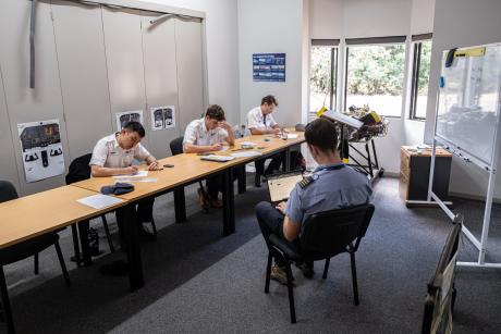 Flight instructor supervising student exam in classroom