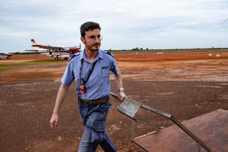 Pilot pulling baggage trolley